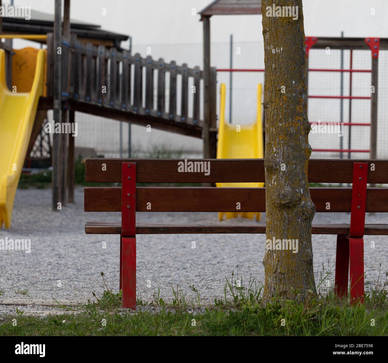 Bank mit Blick auf einen menschenleeren Kinderspielplatz in einem Stadtzentrum Konzept der verlassenen Orte aufgrund der Sperrung für die Coronavirus oder Covid-19 pande Stockfoto