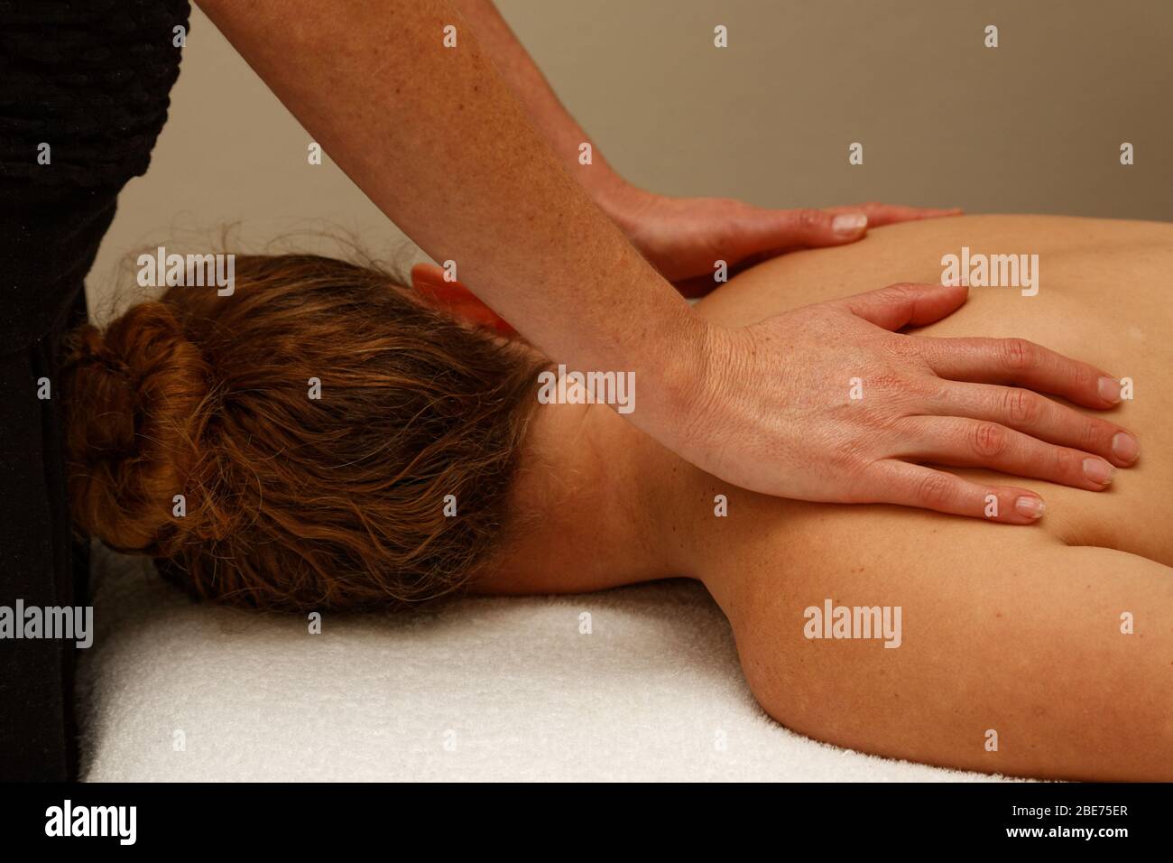 Therapeutische Massage der Schultern. Ein Paar Hände auf den Schultern. Stockfoto