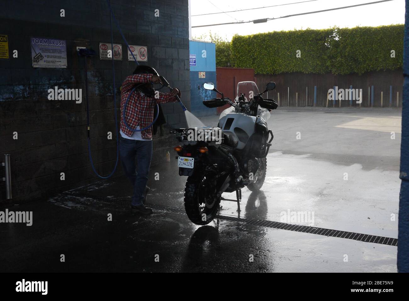 Motorradfahrer wäscht sein Fahrrad Stockfoto