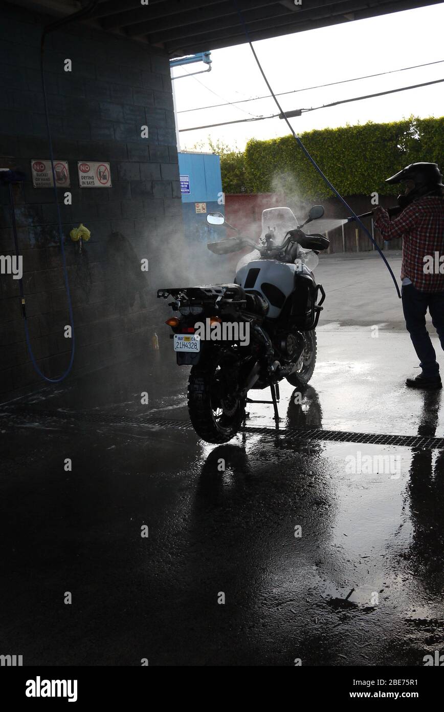 Motorradfahrer wäscht sein Fahrrad Stockfoto