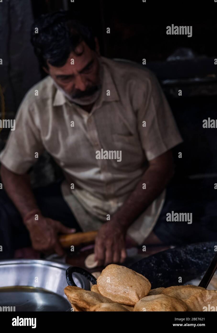 Ein Mann, der puri (poori) bhaji - ein traditionelles indisches Straßenfrühstück - in Varanasi, Indien, herstellt Stockfoto