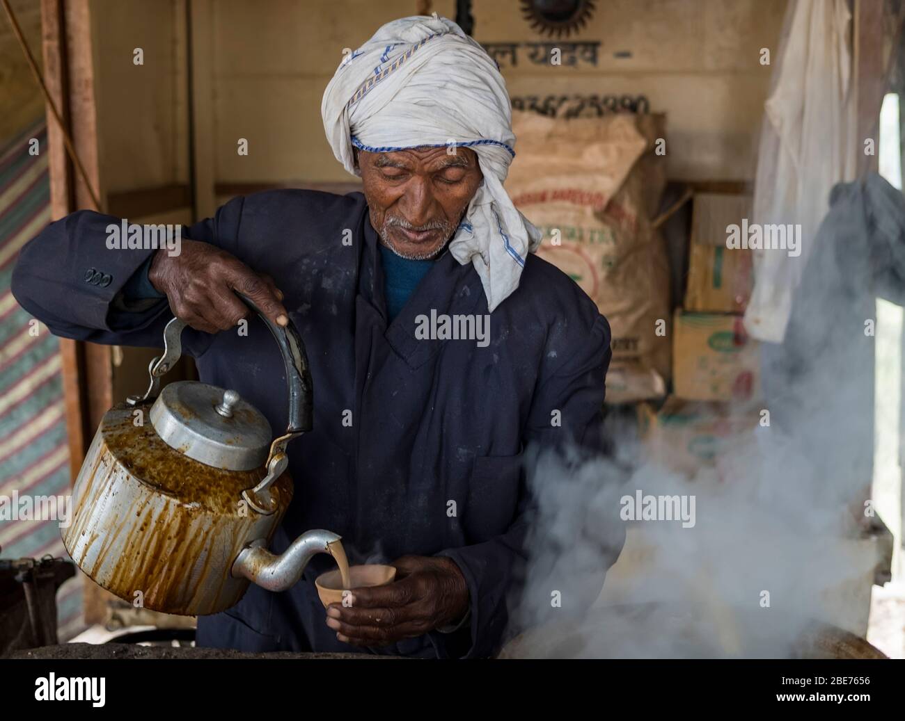 Ein alter Inder verkauft heißen, dampfenden Chai in eine Mütze Stockfoto