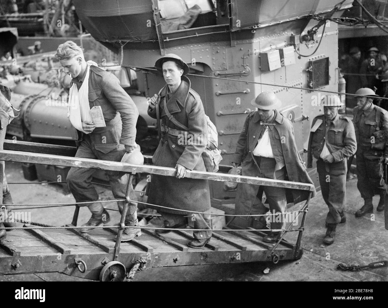 Verwundete britische Soldaten, die aus Dunkirk evakuiert wurden, machen sich von einem Zerstörer in Dover auf den Weg über die Gangplanke. Britische Soldaten, die "Walking Verwunded" sind, ziehen sich von einem Zerstörer, Dover, 31. Mai 1940, auf die Gangplanke. Stockfoto