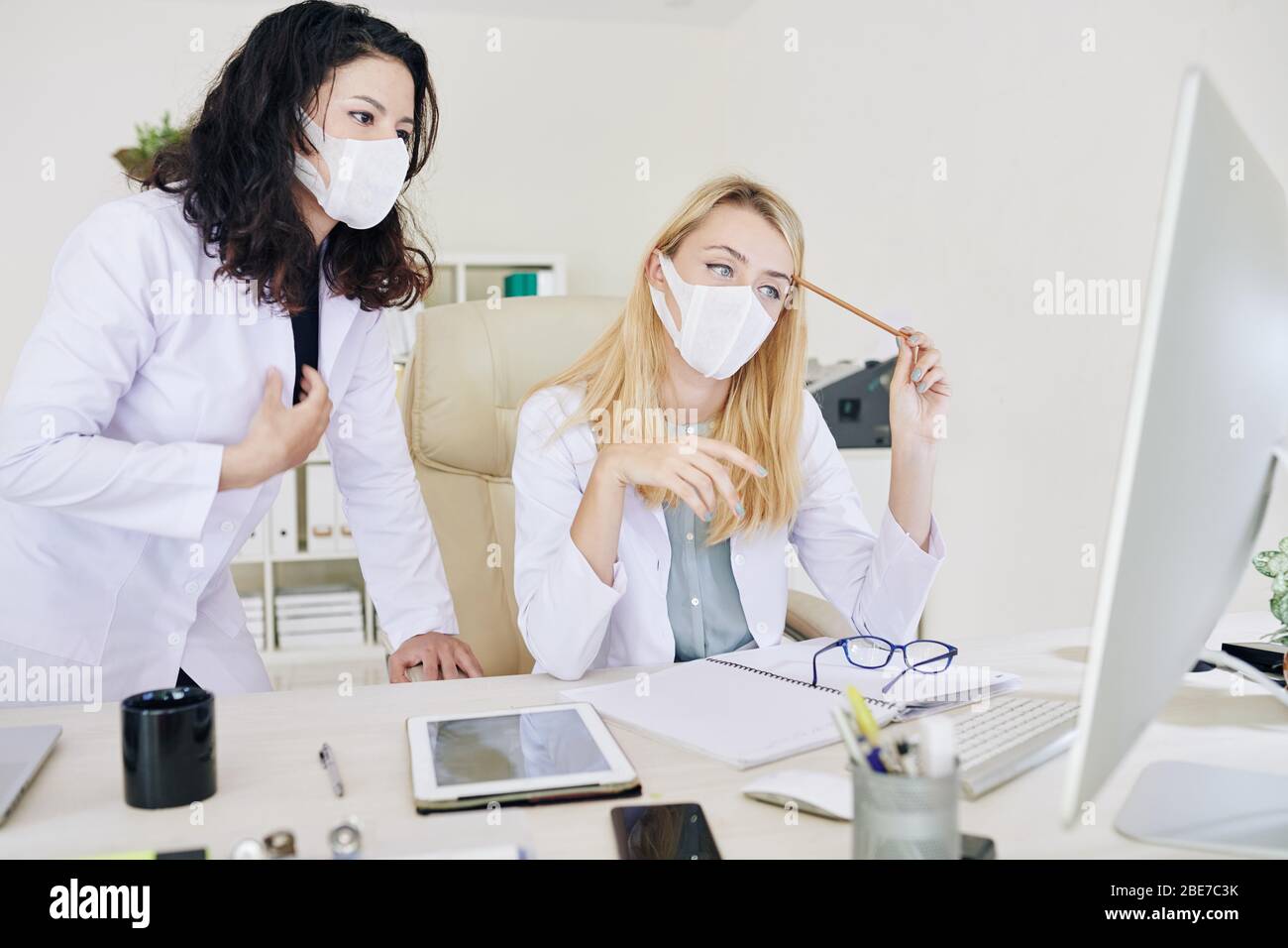 Junge schwere medizinische Arbeiter lesen Dokument mit Virus spead vorbeugende Maßnahmen Stockfoto