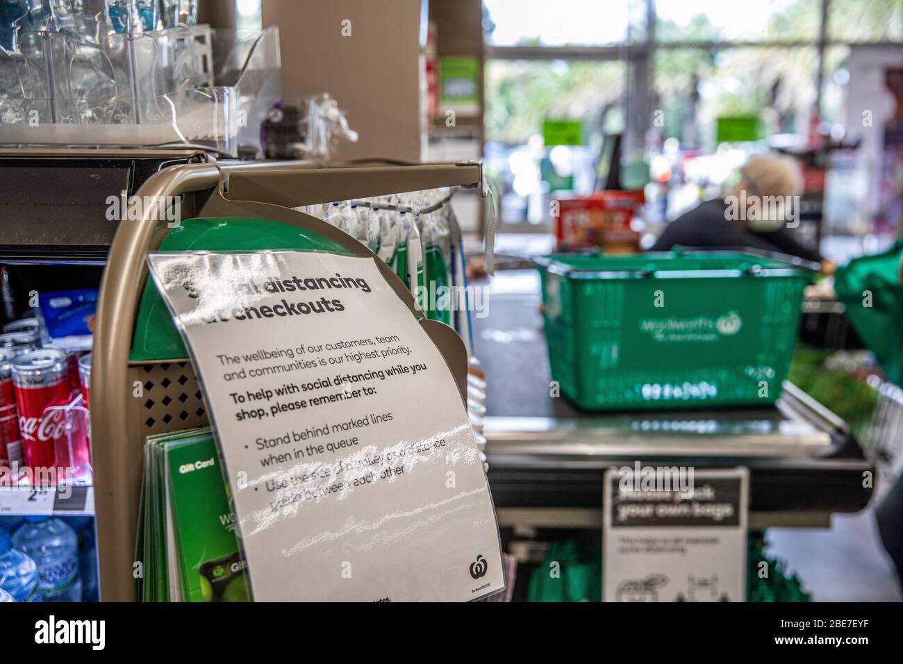 COVID-19 Ära Kasse in einem australischen woolworths Supermarkt mit Zeichen, die Kunden an soziale Distanzierung, Australien Stockfoto