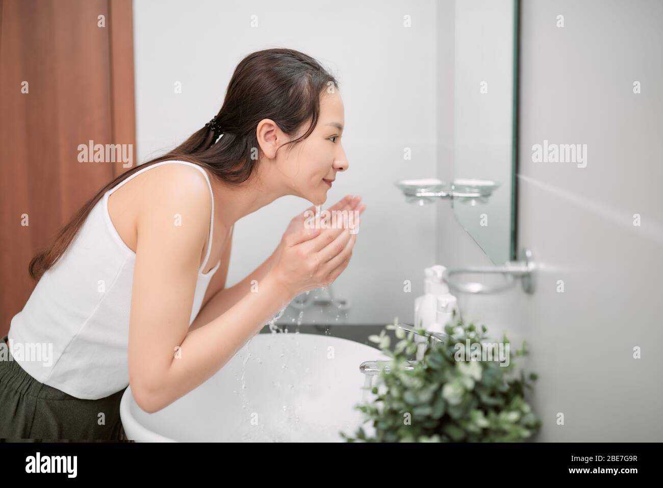 Schönheit asiatische Frau Waschen ihr Gesicht mit sauberem Wasser Stockfoto