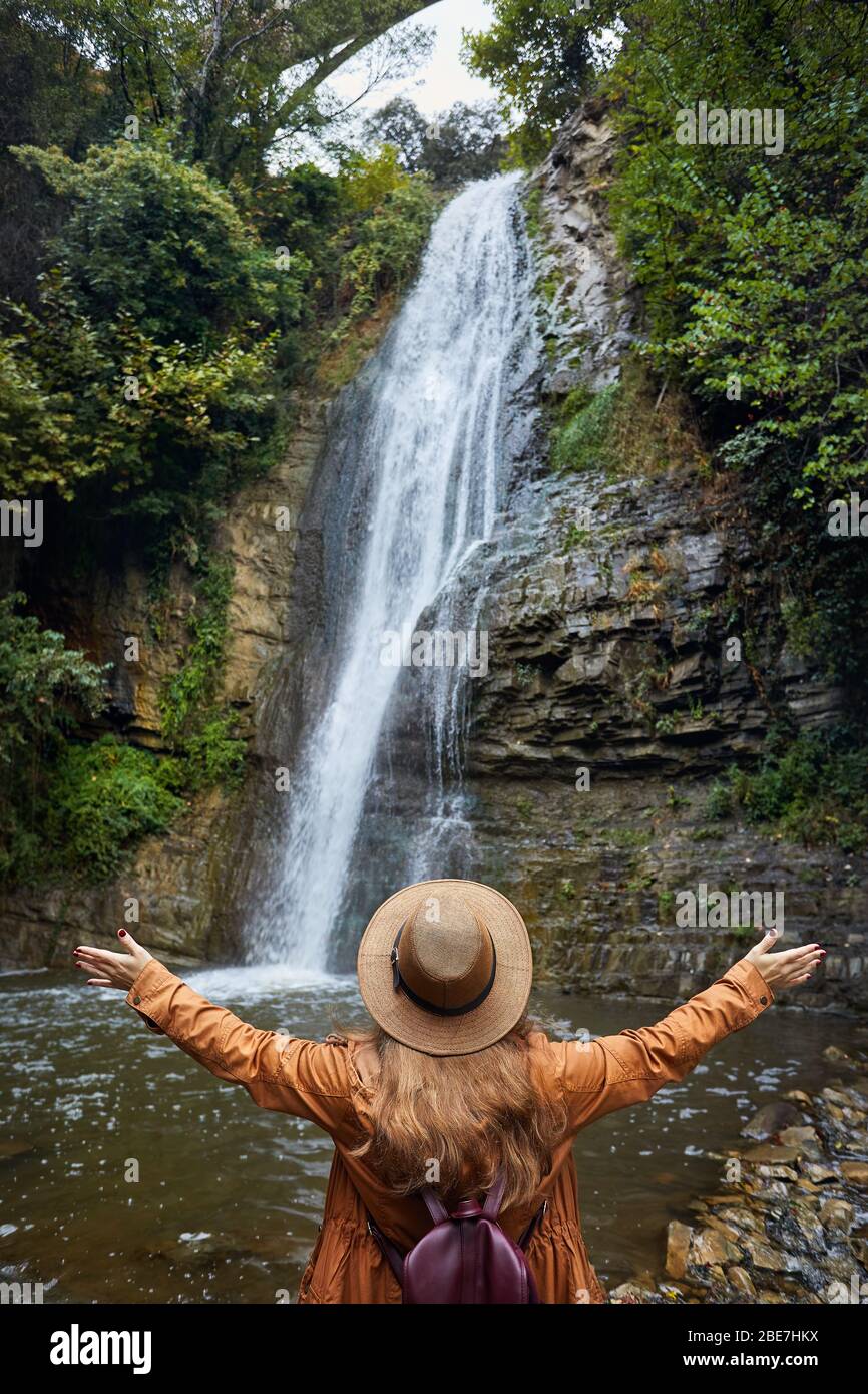 Frau in Hat sich Ihre Hand in der Nähe des Wasserfalls im Botanischen Garten in Tiflis, Georgien Stockfoto