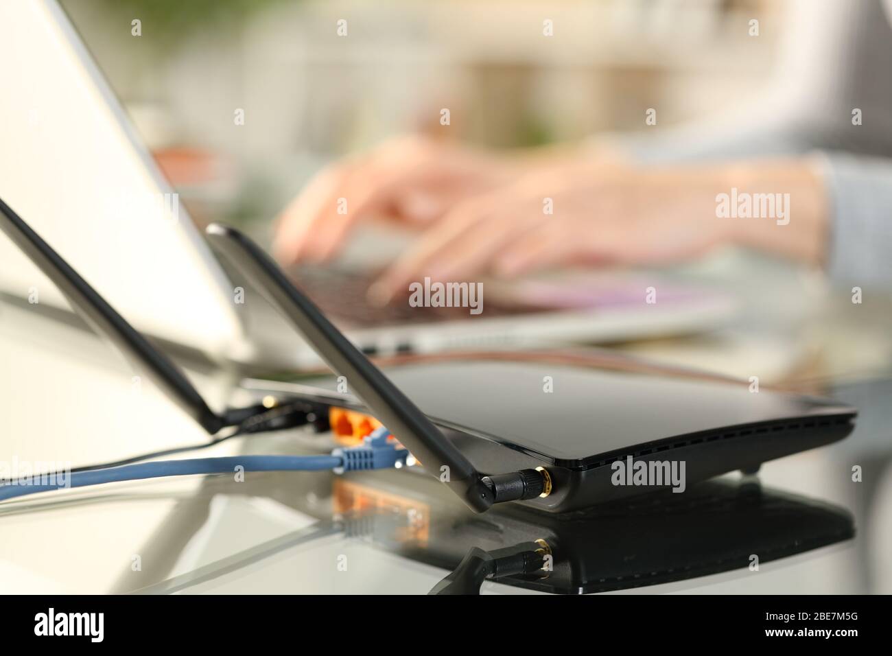 Nahaufnahme des Breitband-Router-WLAN-Verbindung für Frauen Hände mit Laptop auf einem Schreibtisch zu Hause Stockfoto