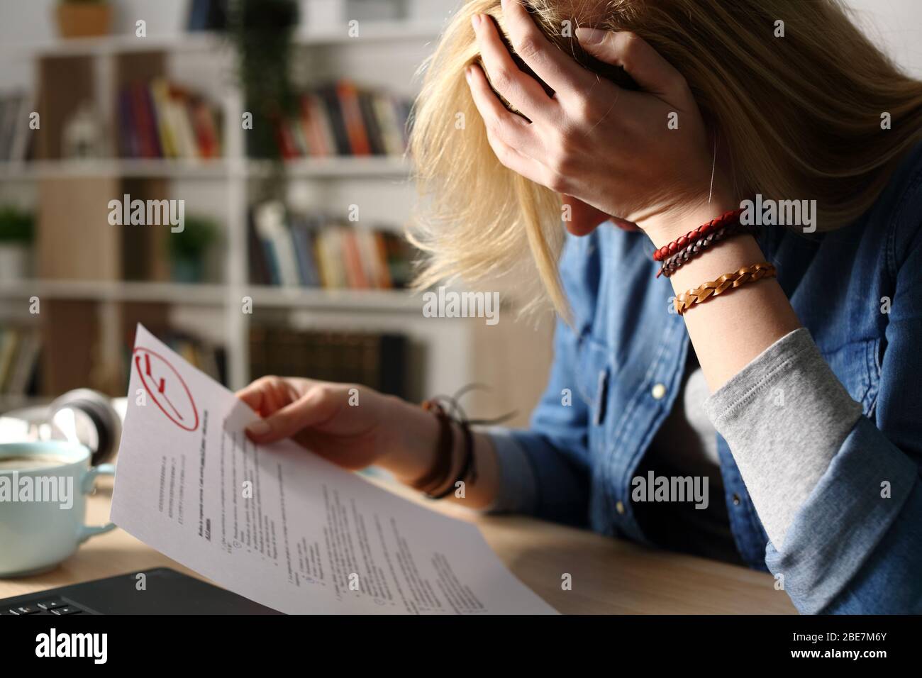 Nahaufnahme eines traurigen Studenten, der sich über fehlgeschlagene Prüfung beschwert, die nachts auf einem Schreibtisch zu Hause sitzt Stockfoto