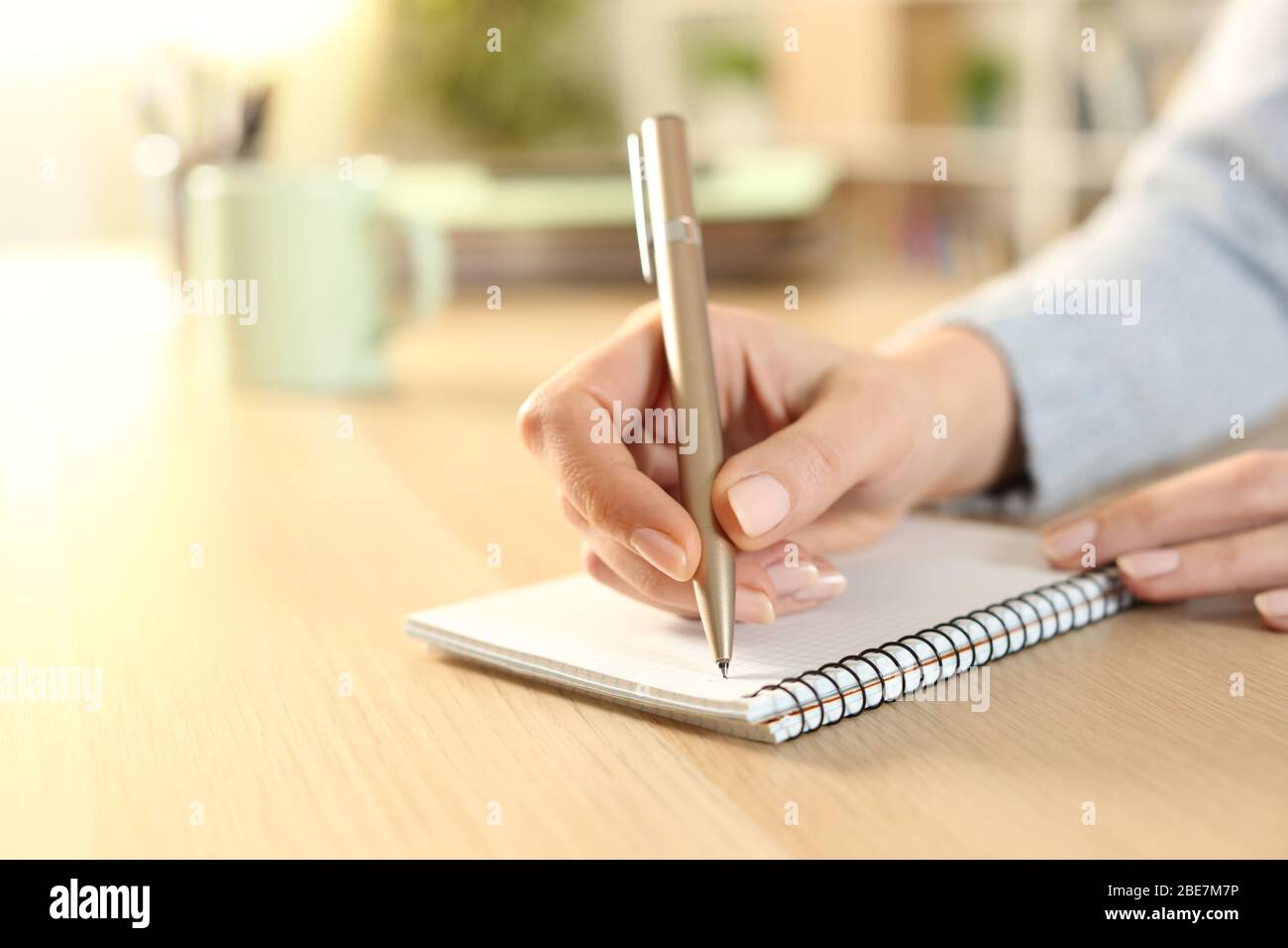 Nahaufnahme der Hände der Frau Schreiben auf Notebook auf dem Schreibtisch zu Hause Stockfoto