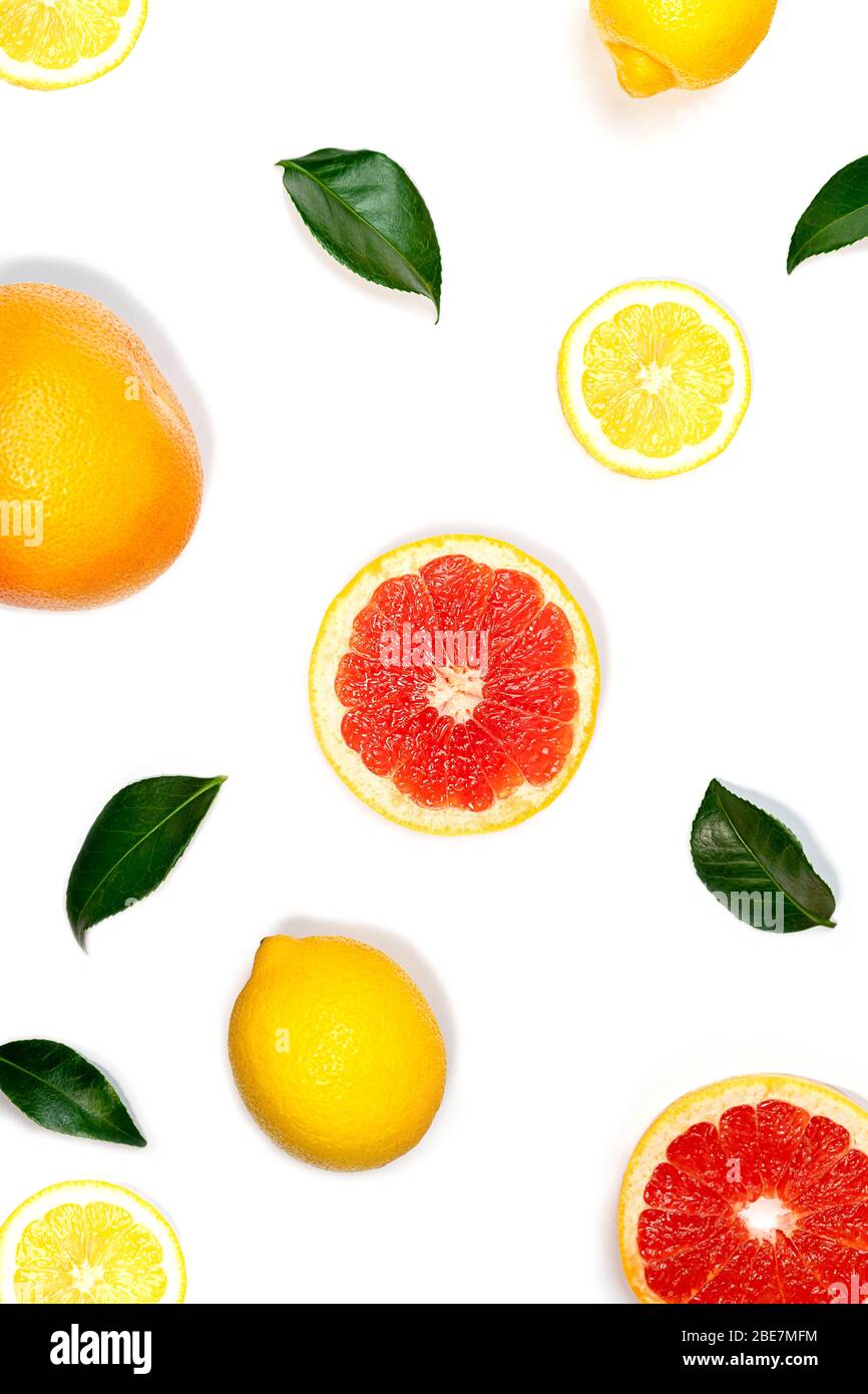 Kreatives Layout aus Zitrone, Grapefruit und grünen Blättern auf weißem Hintergrund. Flach liegend, Nahaufnahme. Sommer-Konzept mit tropischem Essen. Stockfoto