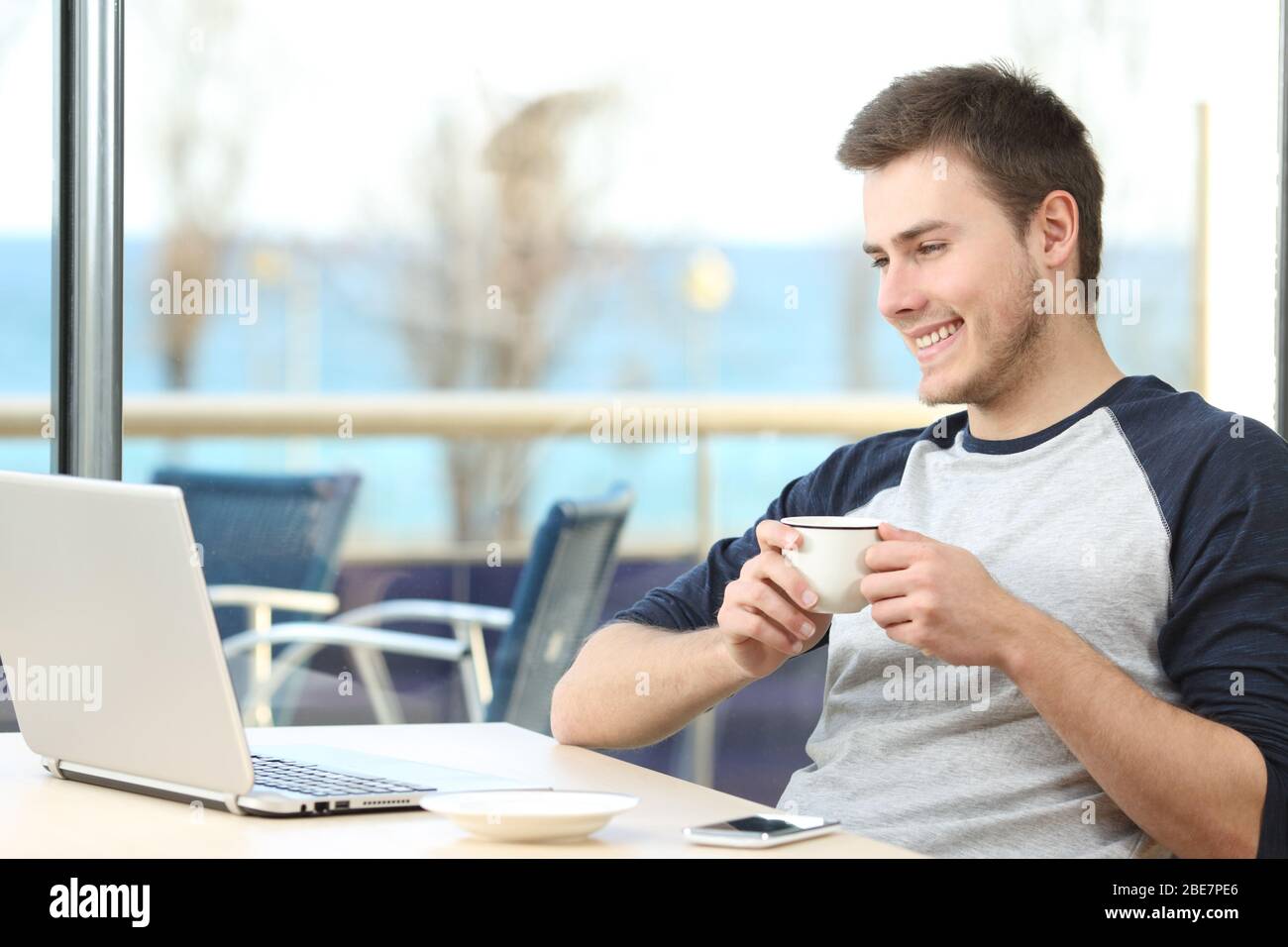 Glücklich Mann Online-Inhalte auf Laptop in einem Café Stockfoto