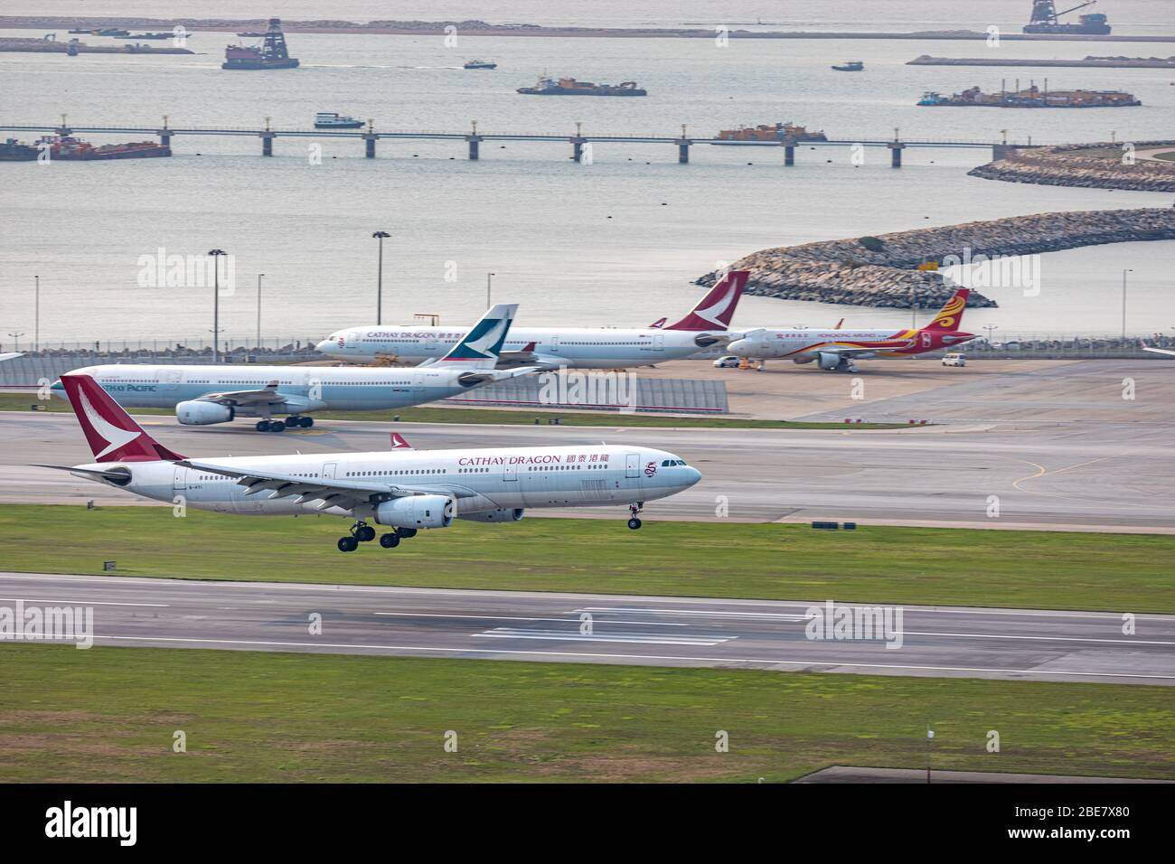 Lantau, Hong Kong - 10. April 2020 : Cathay Drachens Passagierflugzeug landet auf der Landebahn, alle Parkplätze sind wegen COVID voll belegt. Stockfoto