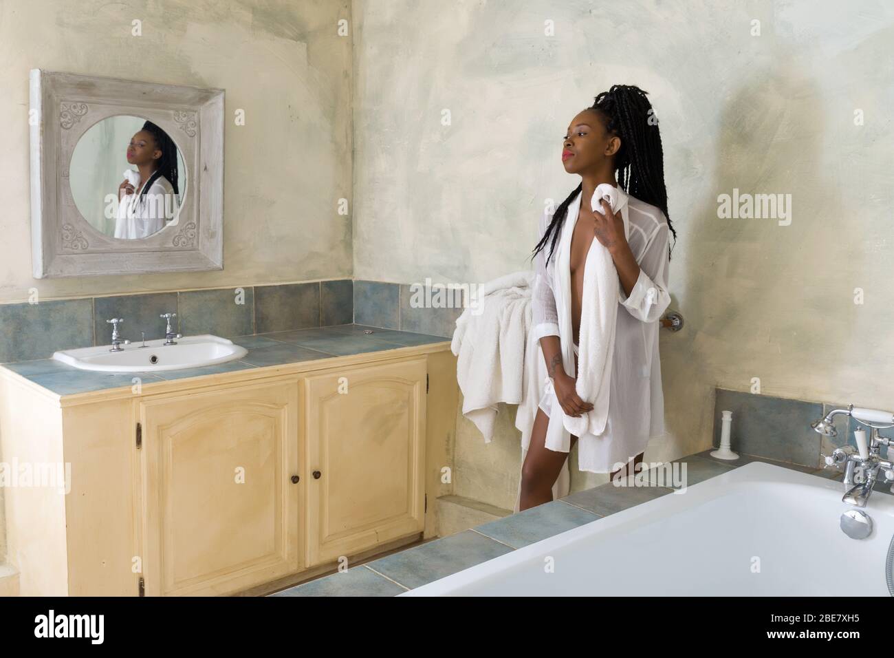Schöne junge schwarze Frau mit Afro Frisur in einem Vintage White Bad Stockfoto