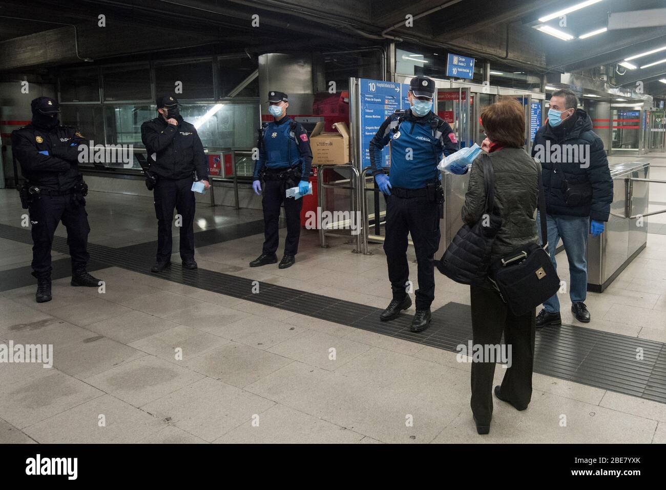 Spanien - Madrid - 13 April, 2020 - Coronavirus-Krise - Gesichtsmasken werden von Polizei und Staatssicherheit an öffentlichen Verkehrsstationen verteilt - nach den letzten Maßnahmen der Regierung öffnet Spanien die Wirtschaftstätigkeit für einige Sektoren wie den Bau. Stockfoto