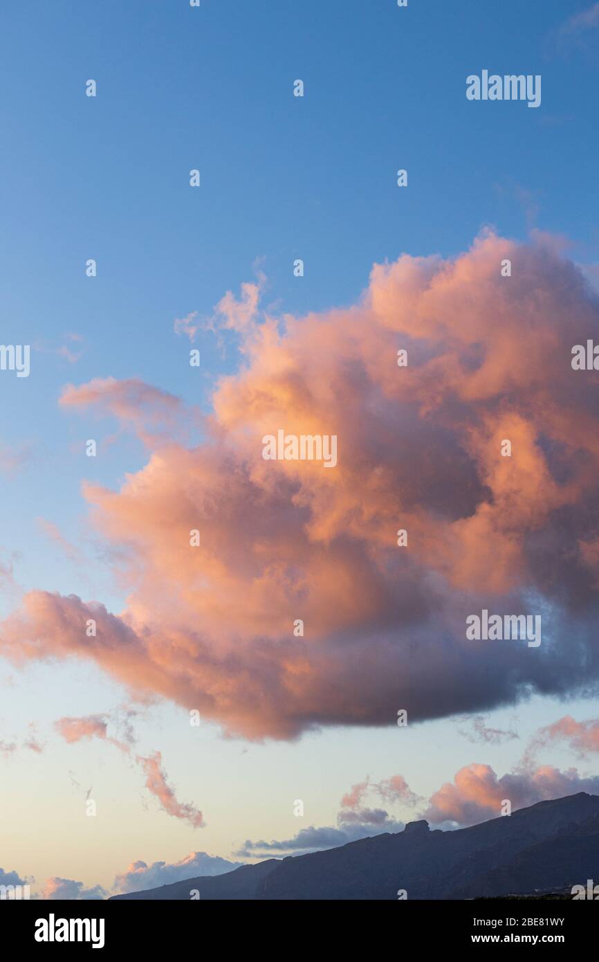 Wolken glühen im reflektierten Sonnenuntergang über den Klippen von Los Gigantes, Playa San Juan, Teneriffa, Kanarische Inseln, Spanien Stockfoto