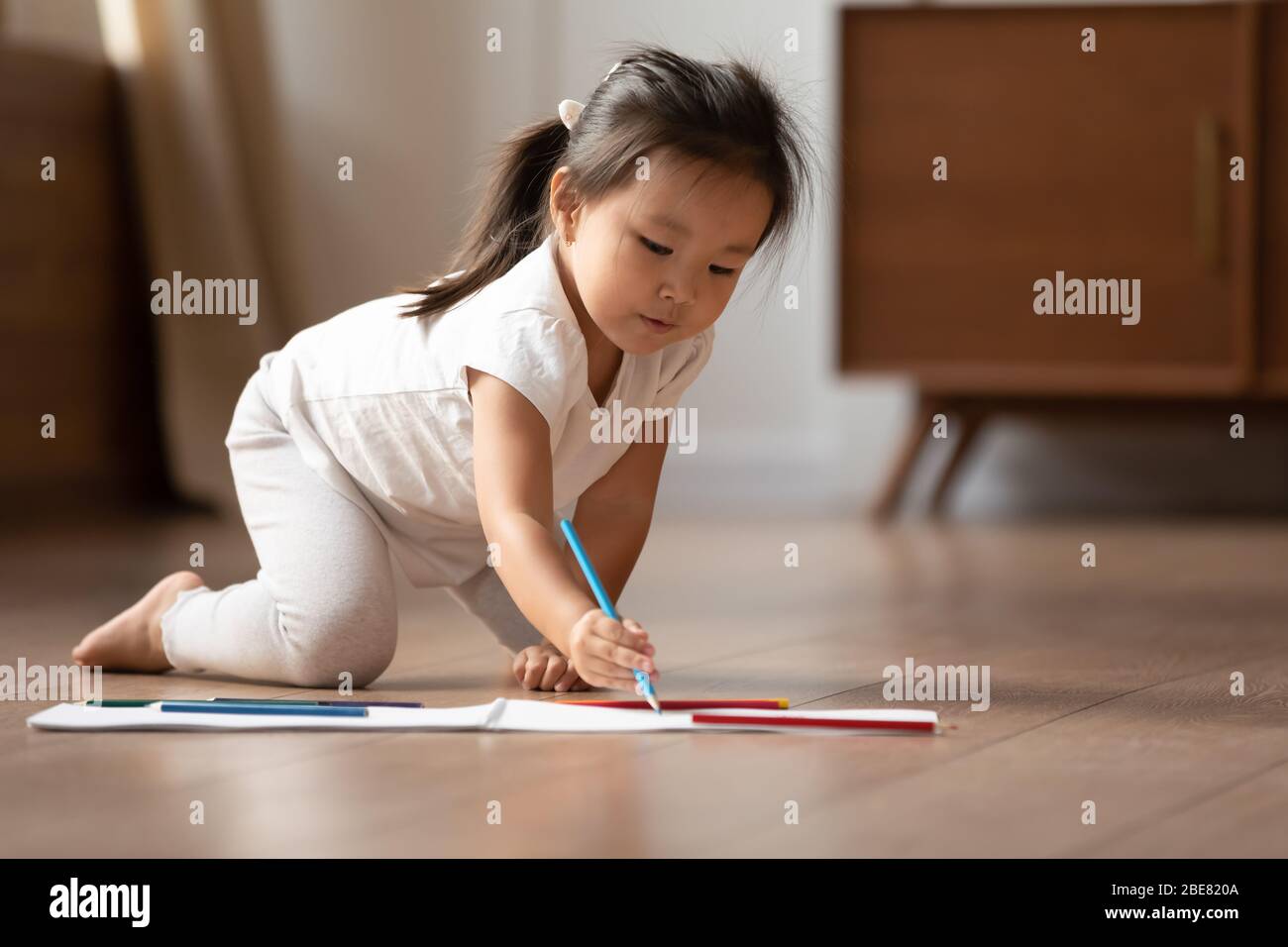 Auf warmen Boden wenig asiatische Mädchen Zeichnung Bilder auf Album Stockfoto