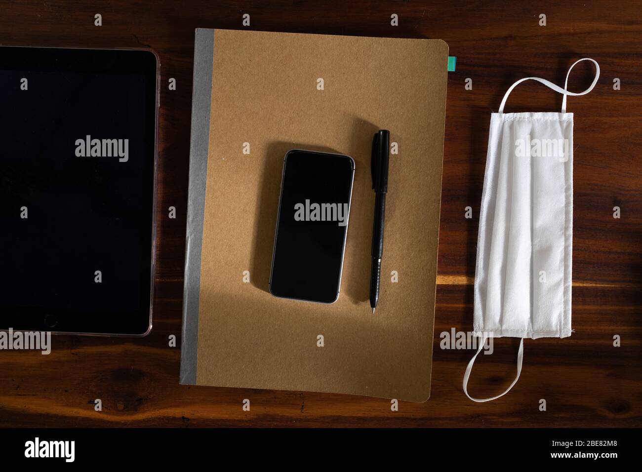 Digitale Tools und Notizbuch auf dem Schreibtisch zu Hause während der Coronavirus Covid19 Pandemie Stockfoto