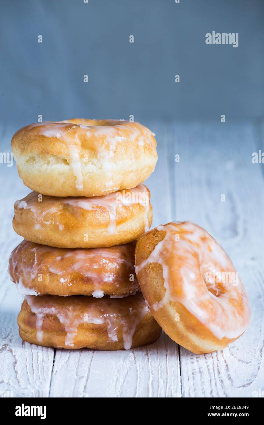 Ein glasierte Donuts auf einem weißen Holzbrett mit Kopierraum gestapelt Stockfoto