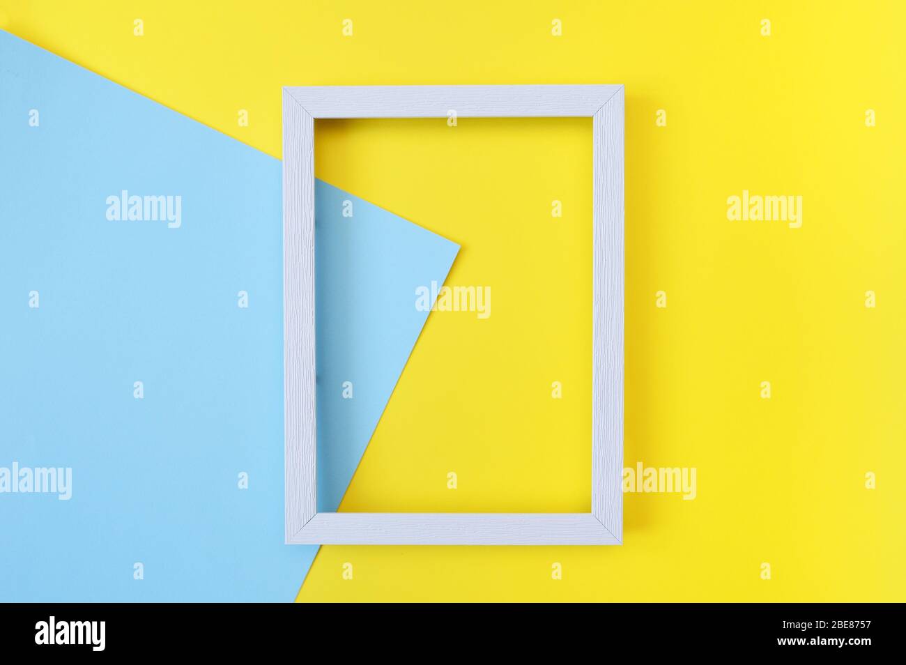 Abstraktes Mock-up mit weißem Holzrahmen auf gelbem und blauem Hintergrund mit Platz für Ihren Text. Für Grußkarten, Hochzeiten, Banner, Poster oder Web Stockfoto