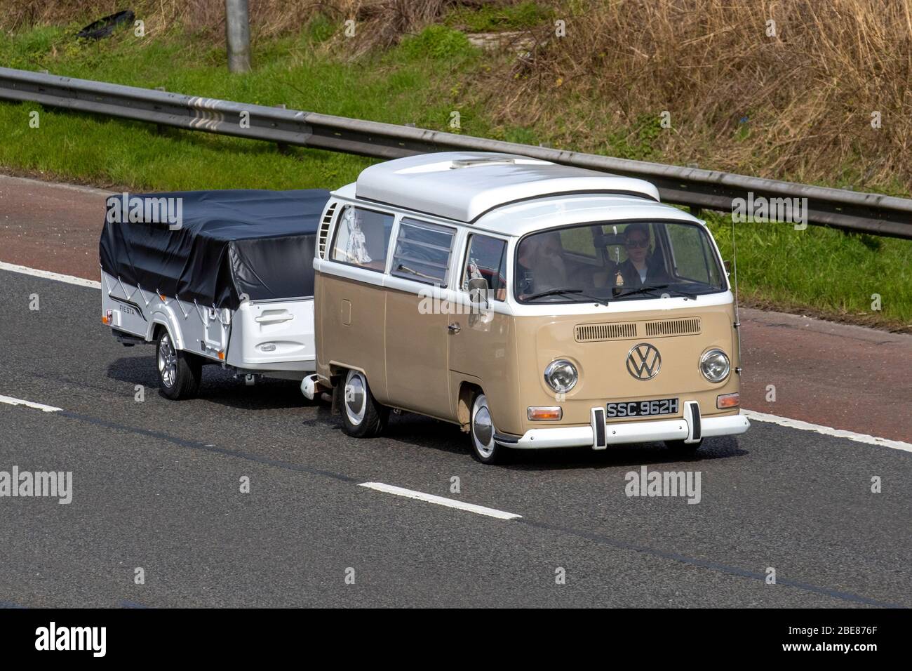 1970 70er Jahre beige Classic VW Volkswagen Pop Top, Schaufenster Caddy, 70er Jahre Wohnmobil schleppen Wohnwagen Anhänger; UK Fahrzeugverkehr, Heritage Transport, bewegte Fahrzeuge, altes Fahrzeug, Straßen, geschätzte Motoren, Oldtimer-Autofahren auf der Autobahn M6 Stockfoto