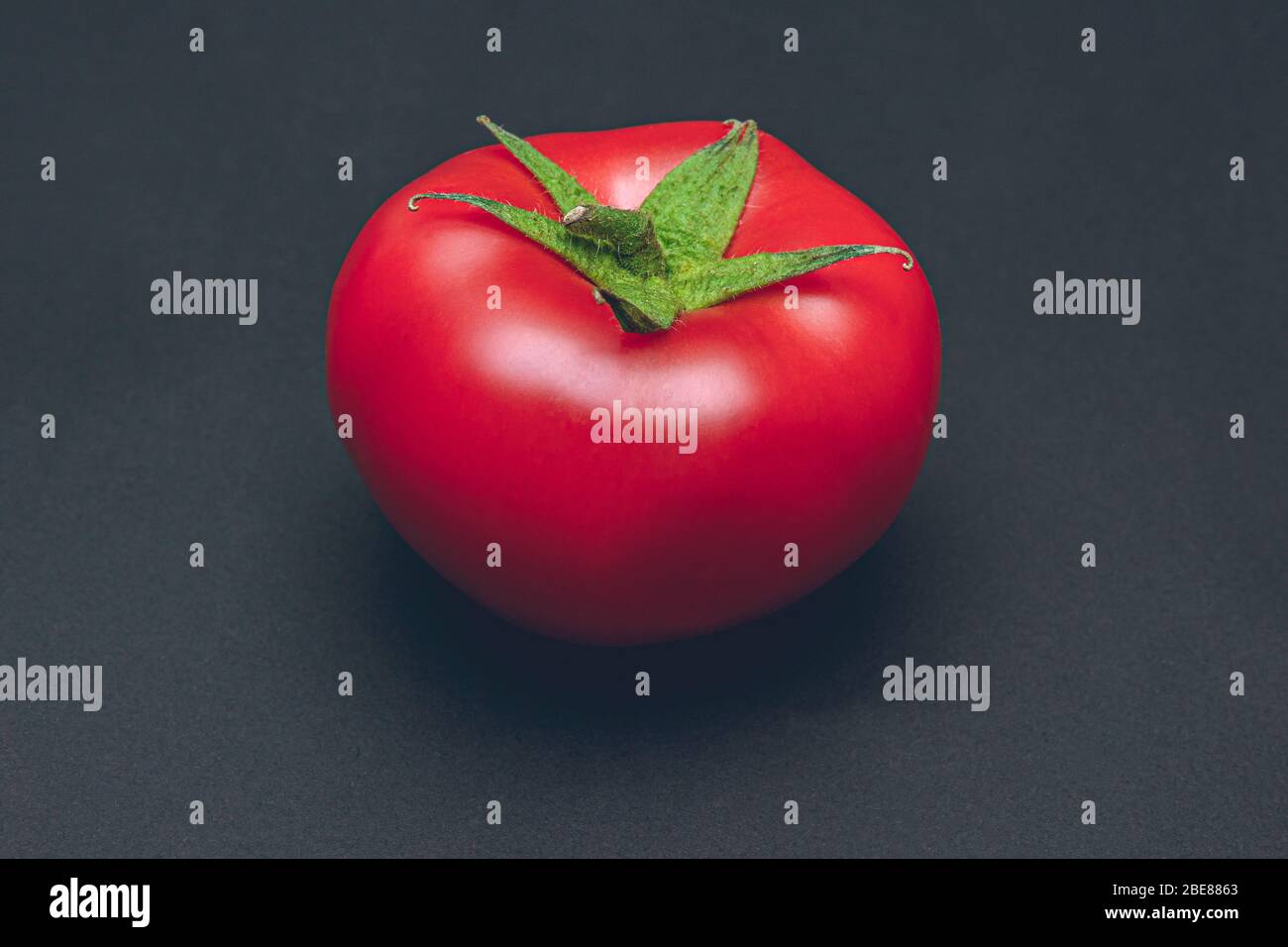 Rote reife Tomate auf schwarzem Hintergrund, Studioaufnahme Stockfoto