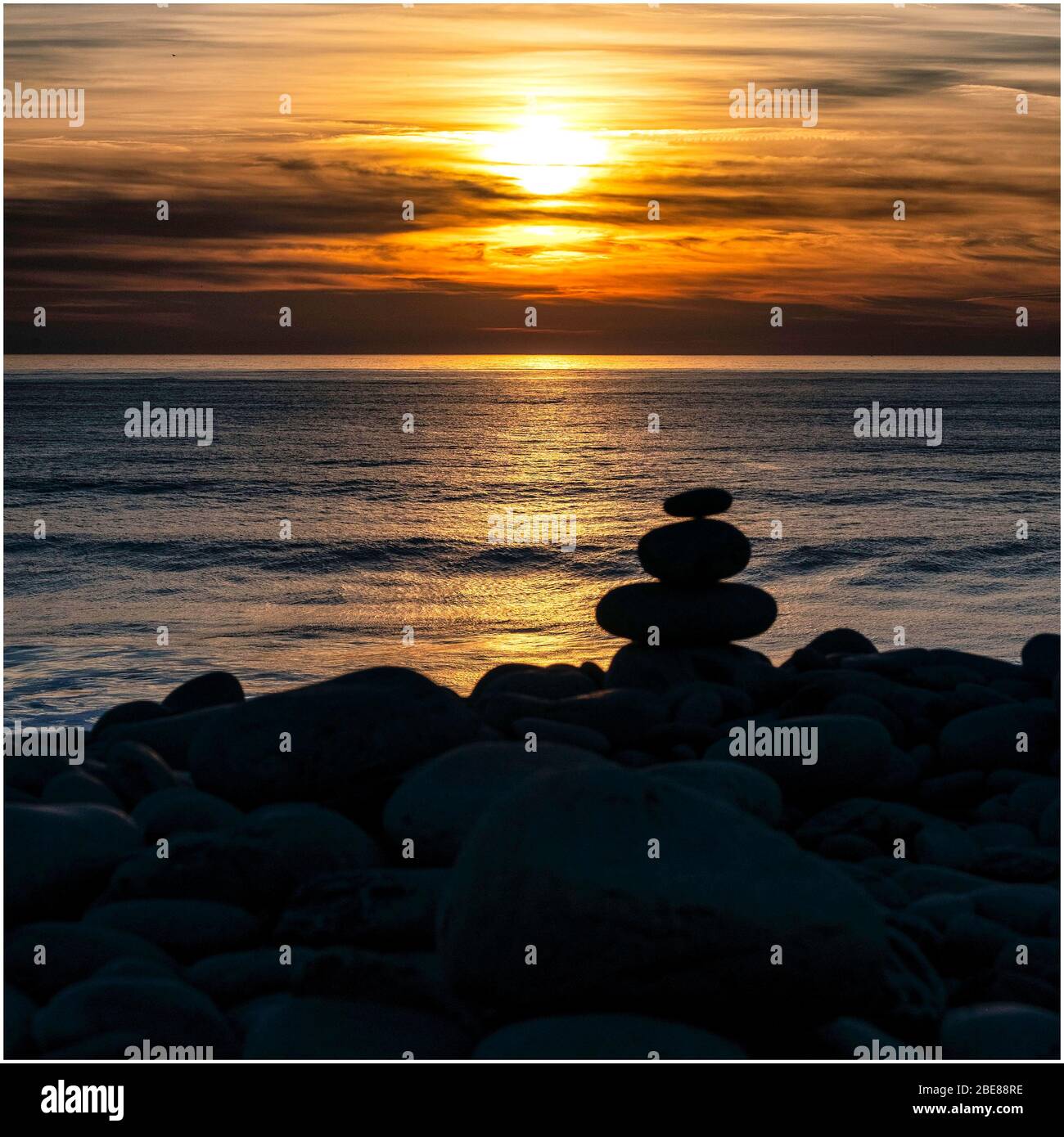 Gestapelte Kieselsteine bei Sonnenuntergang Stockfoto