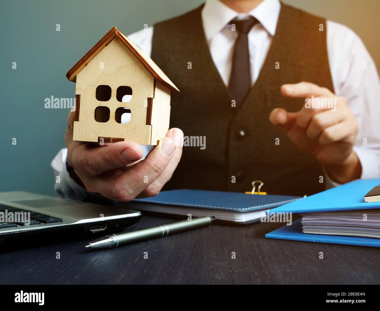 Kaufen Sie zu Hause oder erhalten Hypothek. Makler schlägt Modell des Hauses. Stockfoto