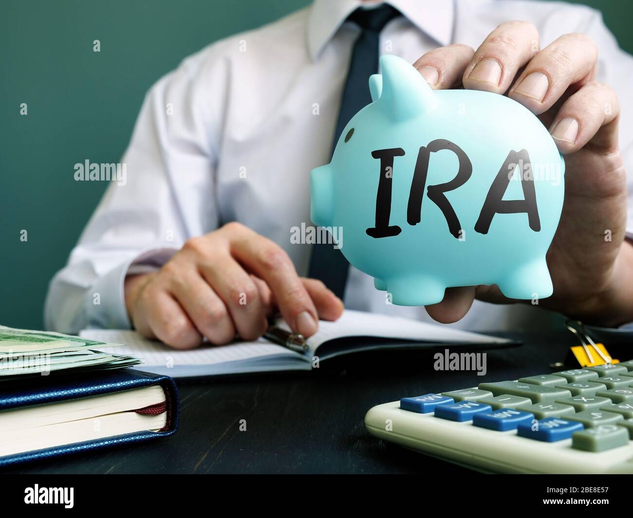 IRA individuelles Pensionierungskonto Konzept. Der Manager schlägt ein Sparschwein vor. Stockfoto IRA individuelles Pensionierungskonto Konzept. Der Manager schlägt ein Sparschwein vor. Stockfoto