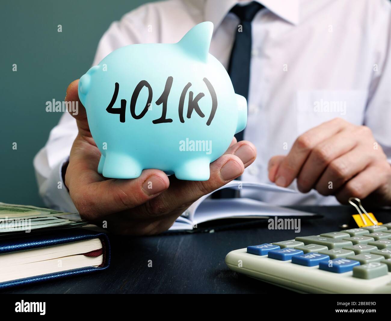 Mann schlägt Sparschwein mit Schild 401k vor. Altersvorsorge. Stockfoto Mann schlägt Sparschwein mit Schild 401k vor. Altersvorsorge. Stockfoto