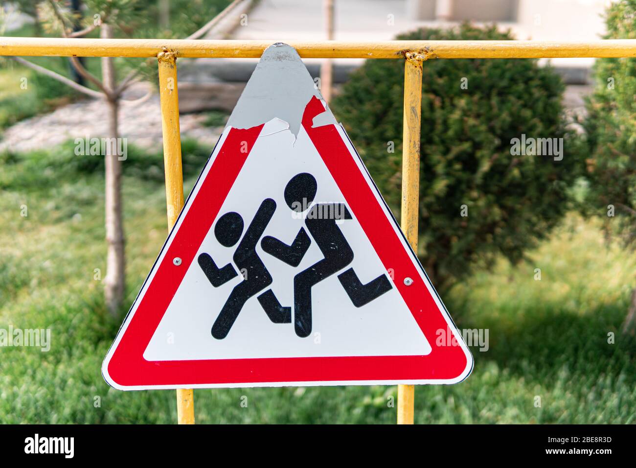 Nahaufnahme von alten und zerkratzten Kindern, die das Straßenschild überqueren Stockfoto