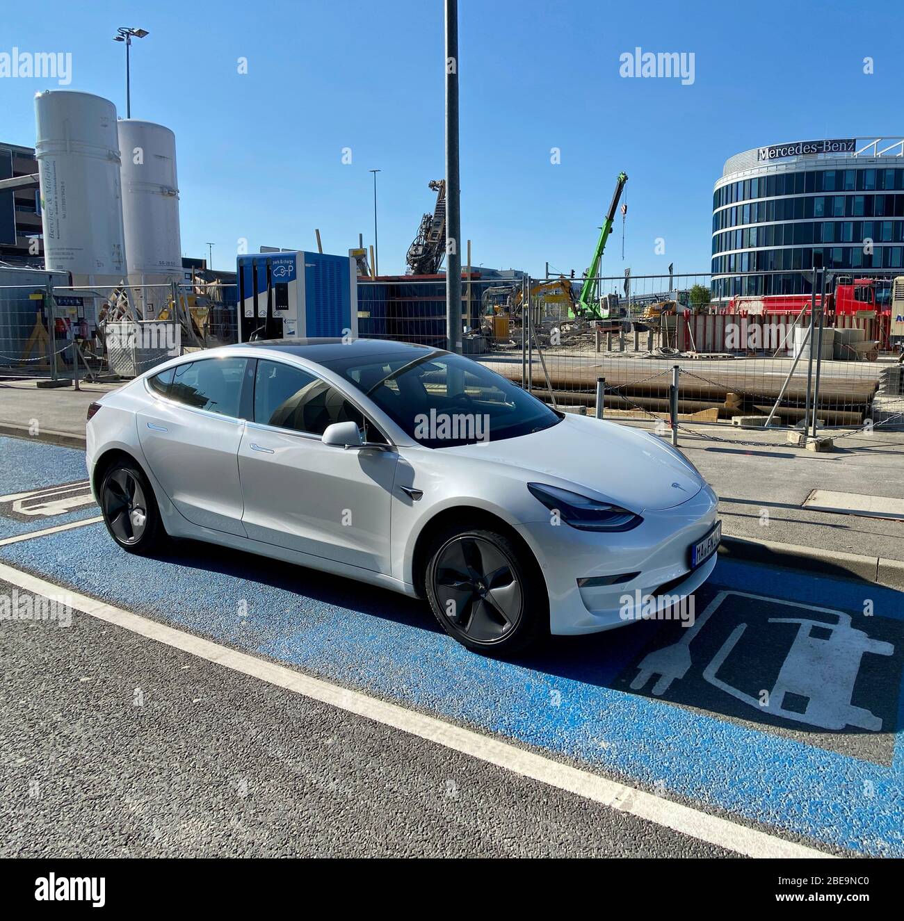 Ein Tesla Model 3 Elektroauto lädt die Batterien auf Stockfoto