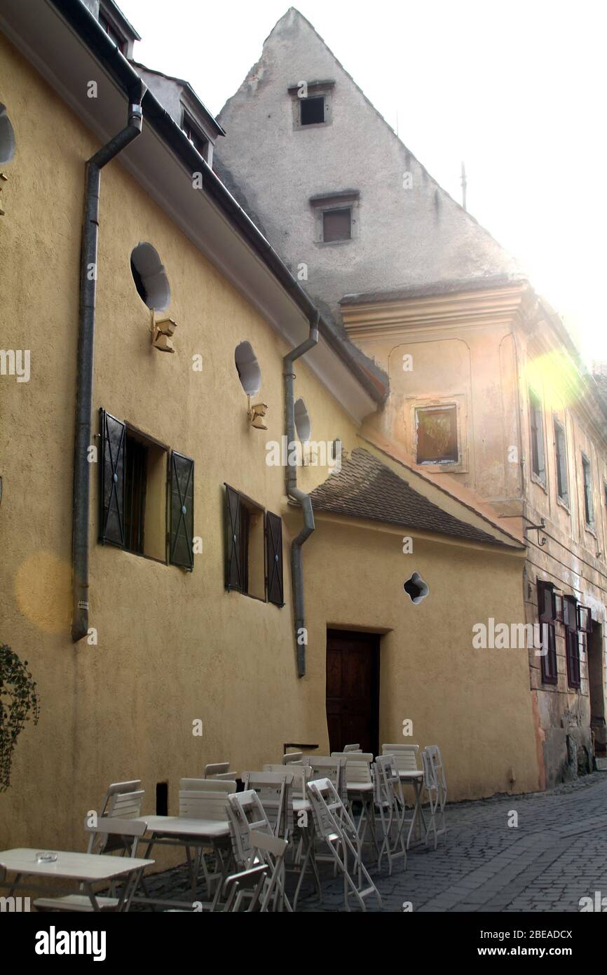 Gebäude in der Altstadt von Brasov, Rumänien. Restaurant auf dem Bürgersteig außerhalb der Öffnungszeiten. Stockfoto