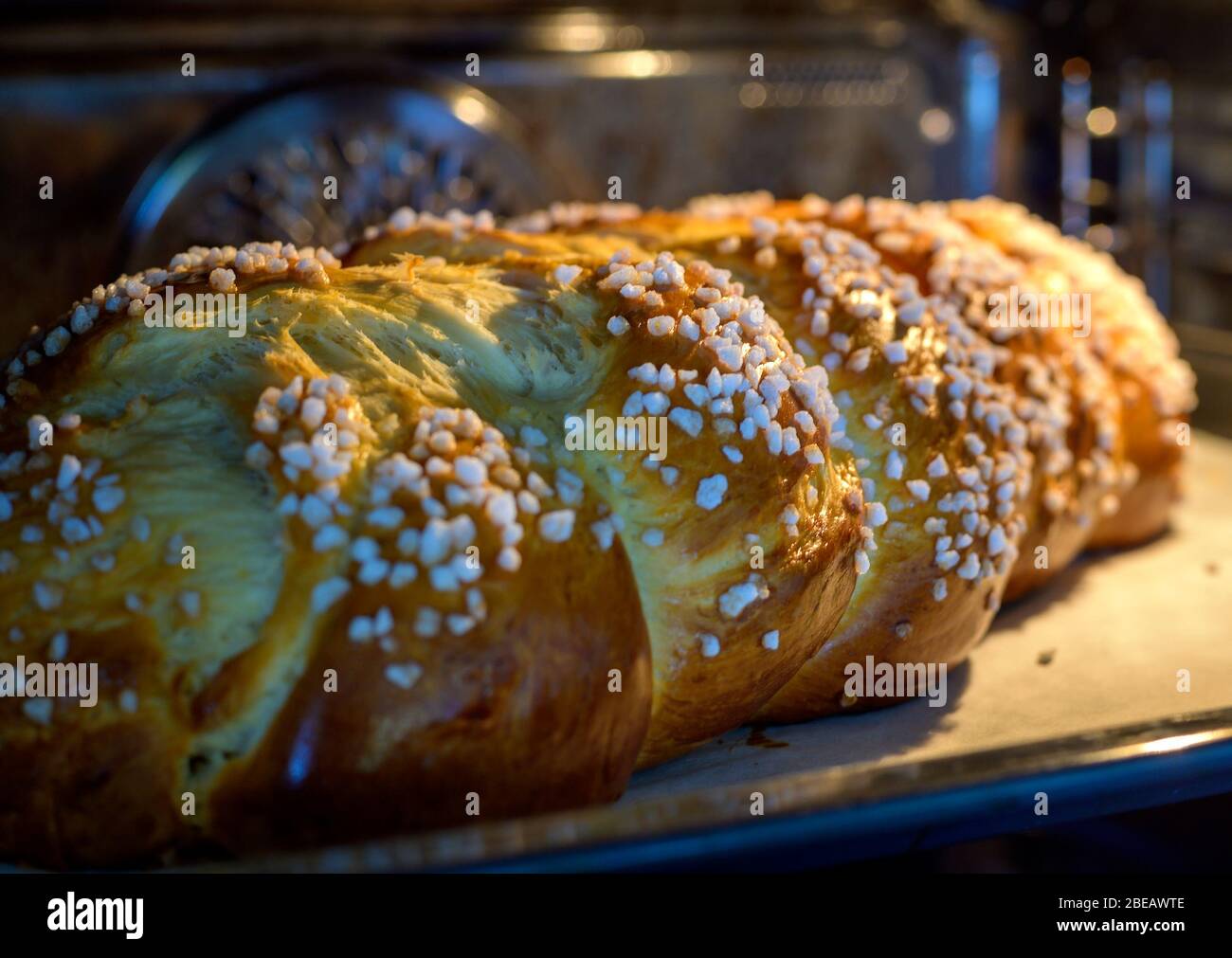 Große geflochtene süße Hefebrot mit grobem Zucker in einem Ofen Stockfoto