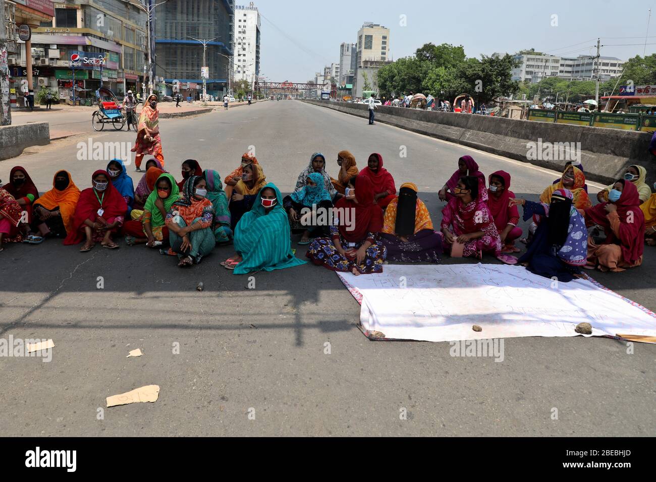 Dhaka, Bangladesch - 13. April 2020: Die Textilarbeiterin aus Bangladesch blockiert eine Straße, während sie sich in einem Protest versammelt, der in Dhaka, Bangladesch, Apr Stockfoto