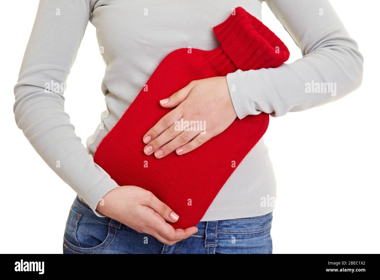 Hände halten eine rote Wärmflasche für Magenschmerzen Stockfoto