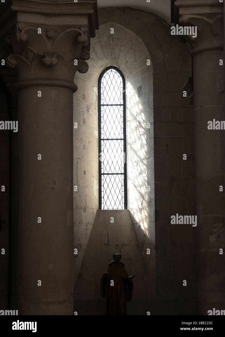 Details von Licht, Fenstern, Mauerwerk und Schatten innerhalb einer klassischen europäischen Kirche. Stockfoto