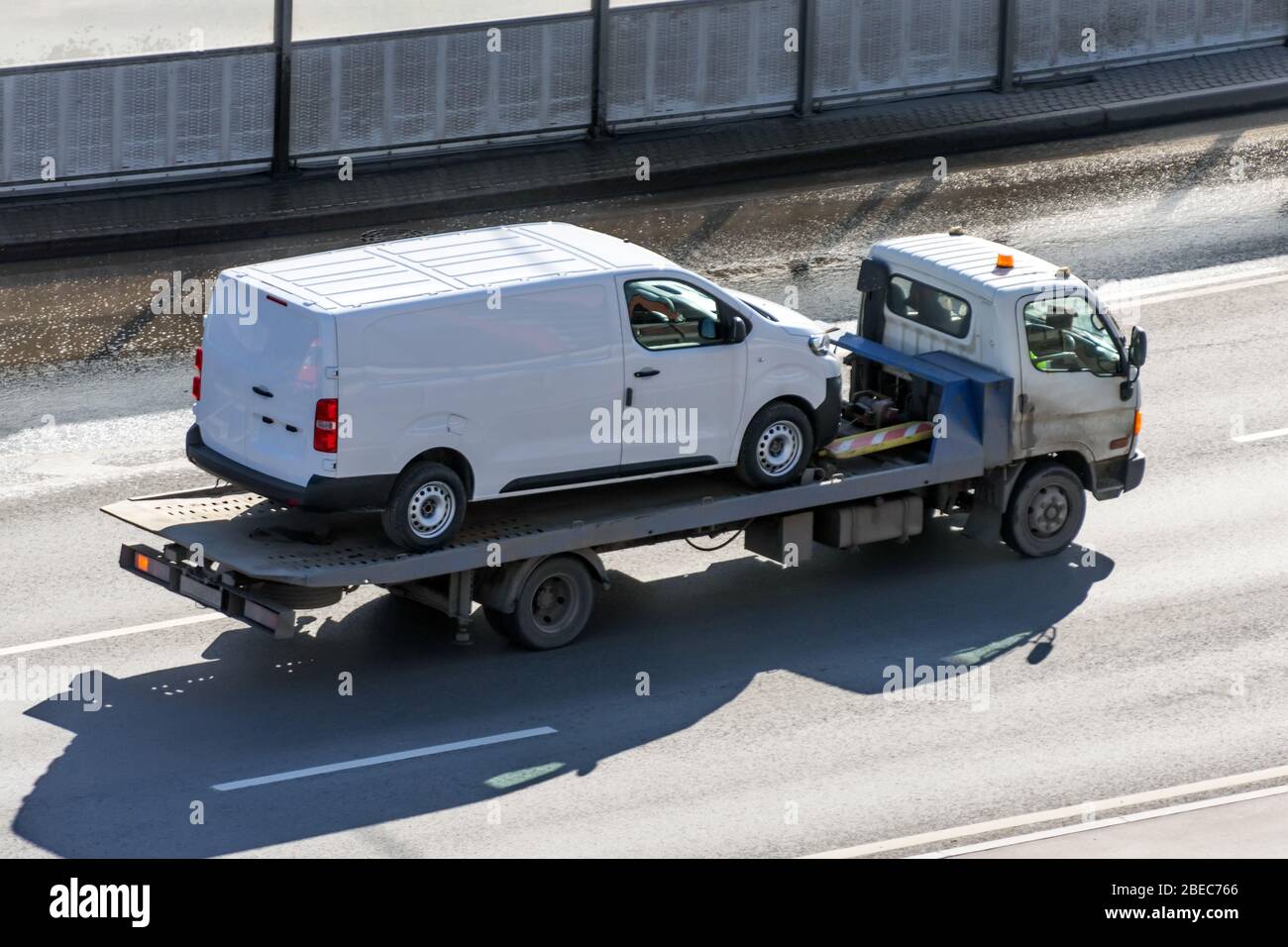 LKW-Träger mit Mini-Van in der Asphaltstraße Stockfoto