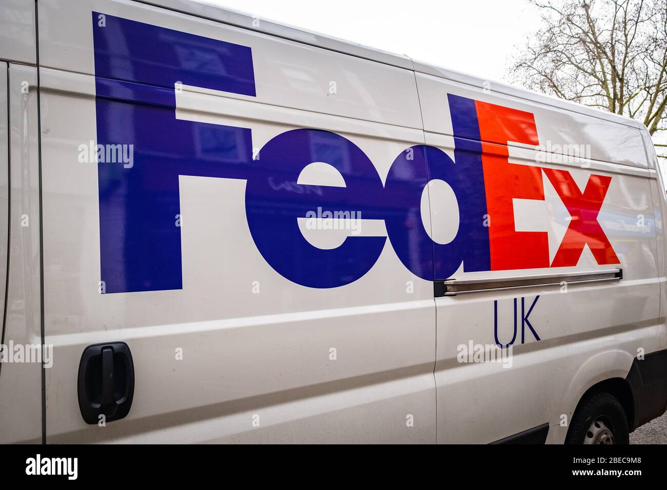 LONDON - JANUAR 2020: FedEx UK Logo in Seite der Lieferung van - amerikanische multinationale globale Versand-und Kurierdienst-Unternehmen Stockfoto