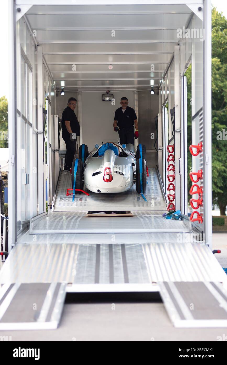 Der einsitzige Mercedes-Benz W196 Silberpfeil-Rennwagen Nr.8 aus dem Jahr 1954 wird aus einem Autotransporter, der bereit für eine Automarckeaustellung ist, entladen. Stockfoto