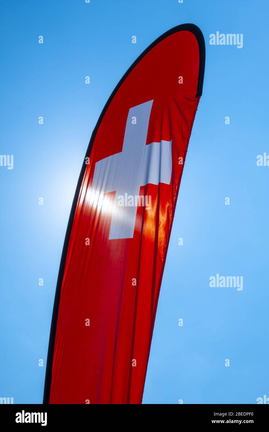 Schweizer Fahne Flagge gegen den blauen Himmel und die Sonne in der Schweiz Stockfoto