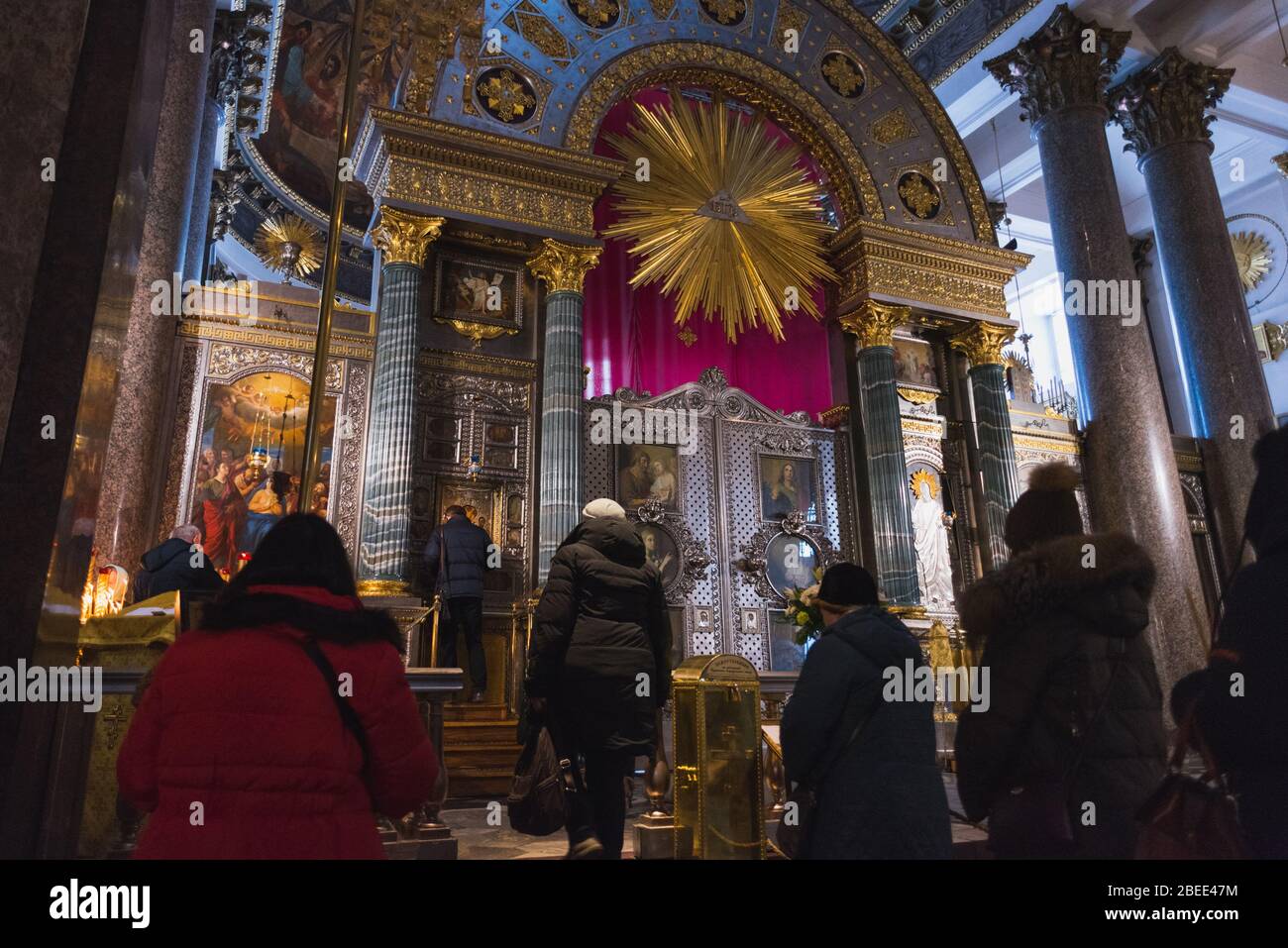 Sankt Petersburg, Russland: Gläubige (nicht erkennbar) stehen in der Kasaner Kathedrale vor Ikonen in einer Reihe. Stockfoto