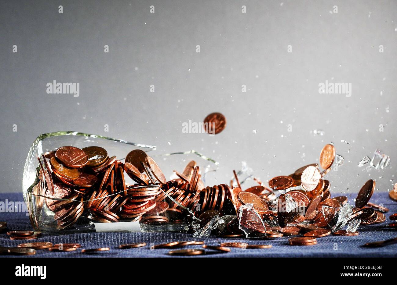 Ein zerschmetterte Gelddose voller britischer Sterling-Münzen Stockfoto