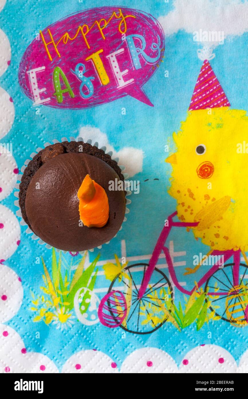 M&S Easter Cupcake auf Easter Serviette Serviette - Mini-Schokolade Cupcakes mit Schokolade Buttercreme und Ostern Dekorationen - Karottentorte Stockfoto
