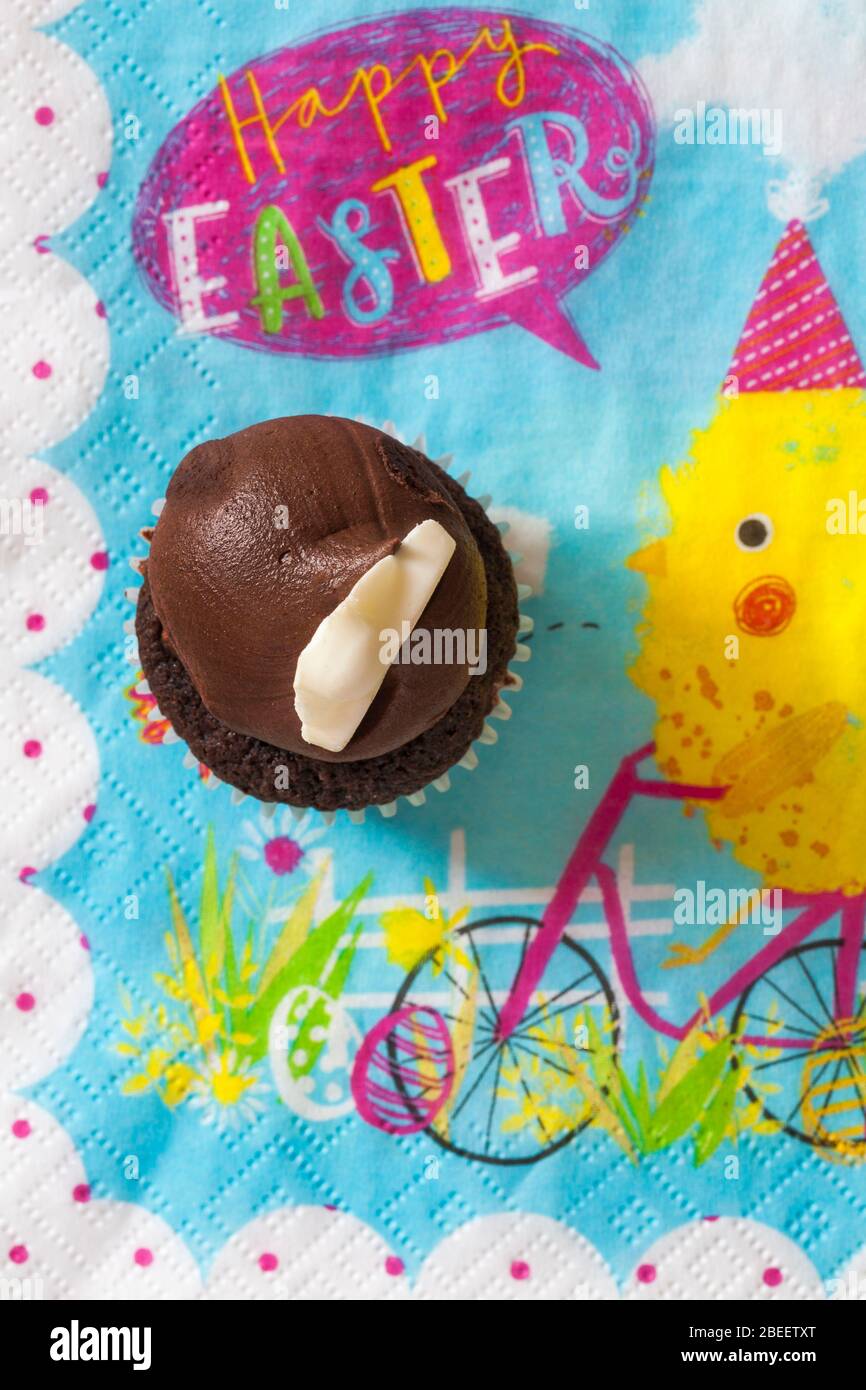 M&S Easter Cupcake auf Serviette Serviette Serviette - Mini-Schokolade Cupcakes mit Schokolade Buttercreme und Ostern Dekorationen - Osterhasen Füße Pfoten Stockfoto