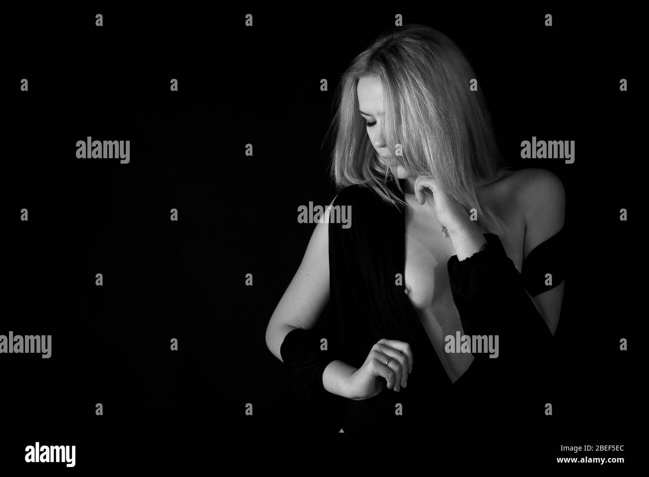 Nahaufnahme, Porträt einer Frau mit einem dummen Moment, während gegen den schwarzen Hintergrund posiert im Studio Stockfoto