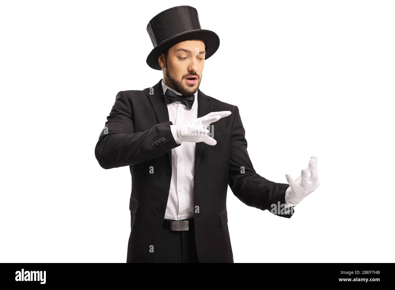 Zauberer trägt weiße Handschuhe und führt einen Trick mit seinen Händen isoliert auf weißem Hintergrund Stockfoto