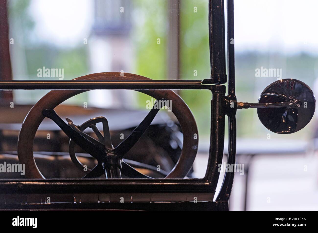 Nahaufnahme eines Lenkrads und Rückspiegel eines antiken Fahrzeugs aus den 1920er Jahren mit offenem Oberdeck Stockfoto