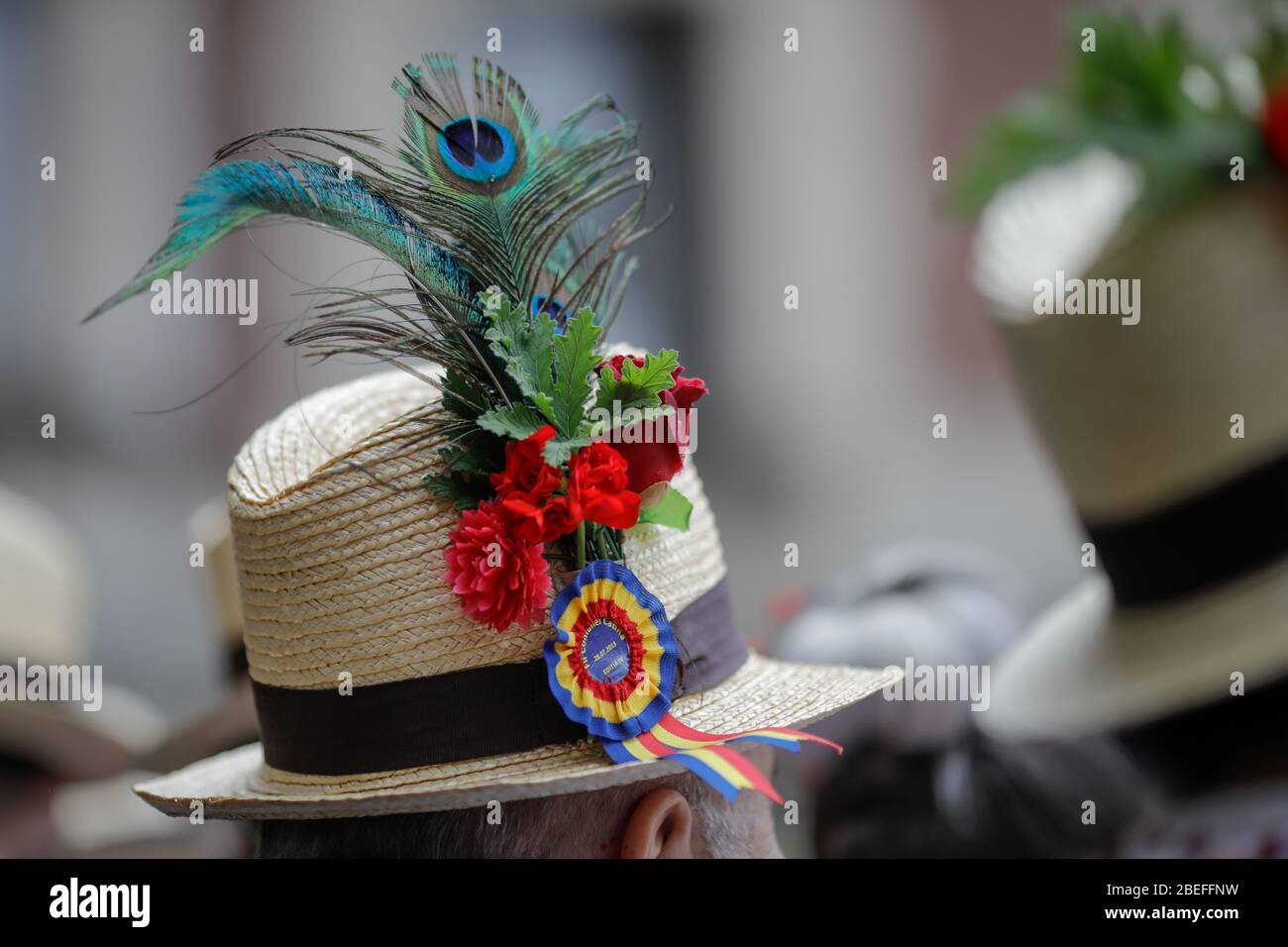 Bukarest, Rumänien - 5. März 2020: Details mit dem traditionellen rumänischen Strohhut eines älteren Mannes, geschmückt mit Blumen, Blättern und Pfauenfedern Stockfoto