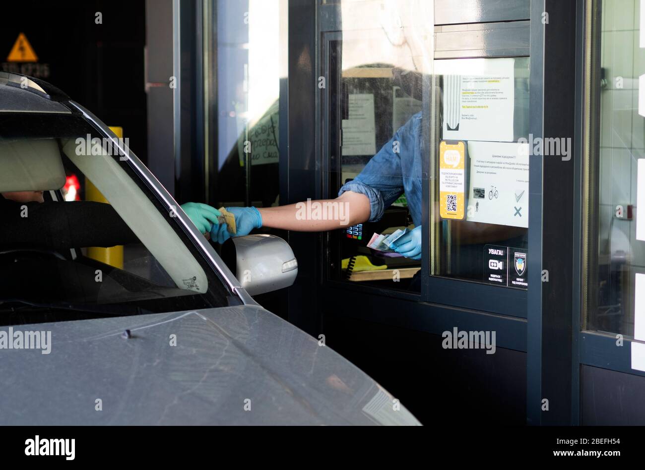 Der Fahrer bezahlt an der Kasse für eine Bestellung bei Mac Drive. In der Ukraine wurde wegen der Pandemie des Coronavirus KOVID-19, die erhebliche Änderungen am Betrieb von Cafés und Restaurants vorgenommen, ein Notfall ausgerufen. Jetzt ist nur noch Essen über Kuriere oder Drive-in erlaubt. Stockfoto